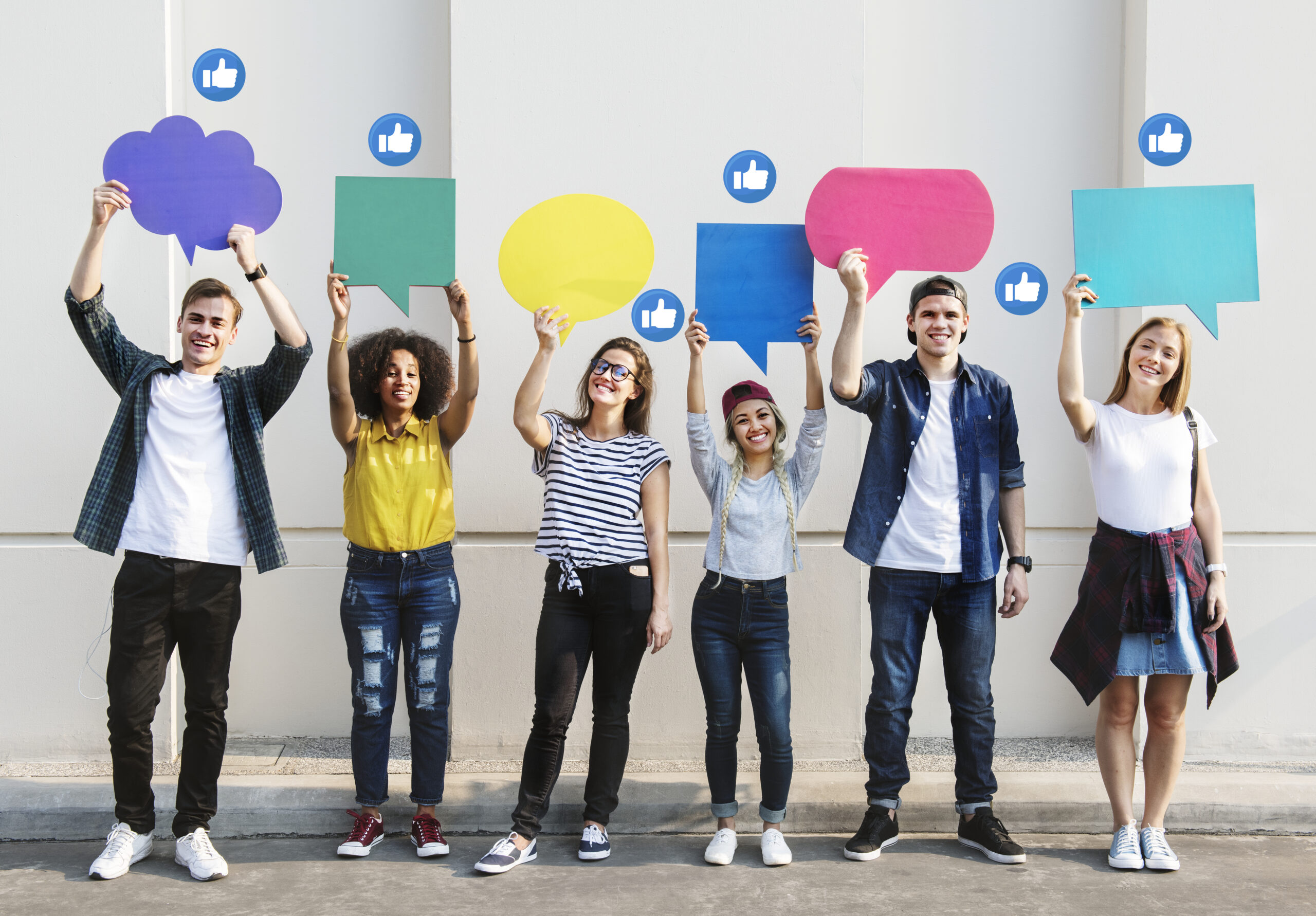 Young adults holding colorful speech bubbles